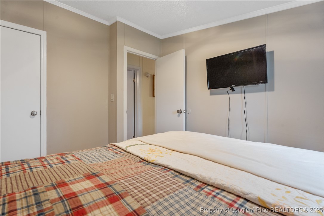 54 West Tryon Court Spring Lake, NC 28390 - Photo 37 of 43 a bedroom with a flat screen tv and a lamp