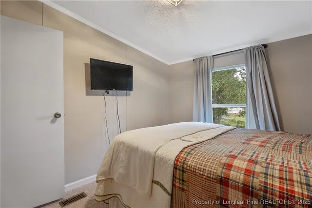 a bedroom with a bed and a flat screen tv