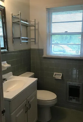 a bathroom with a sink a toilet and a window