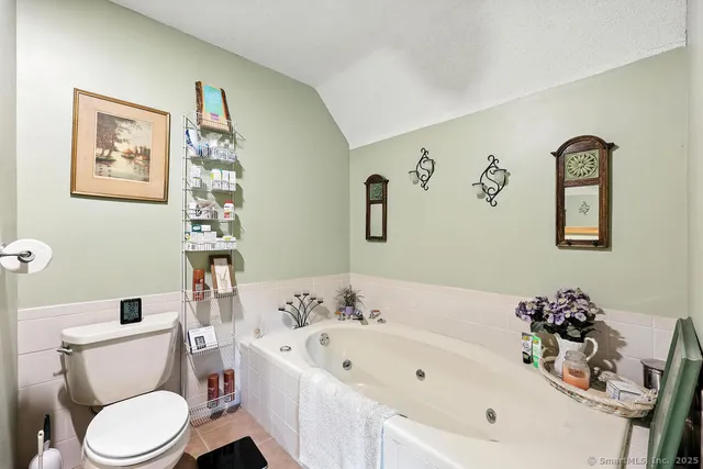 a white toilet sitting next to a bathroom sink and tub