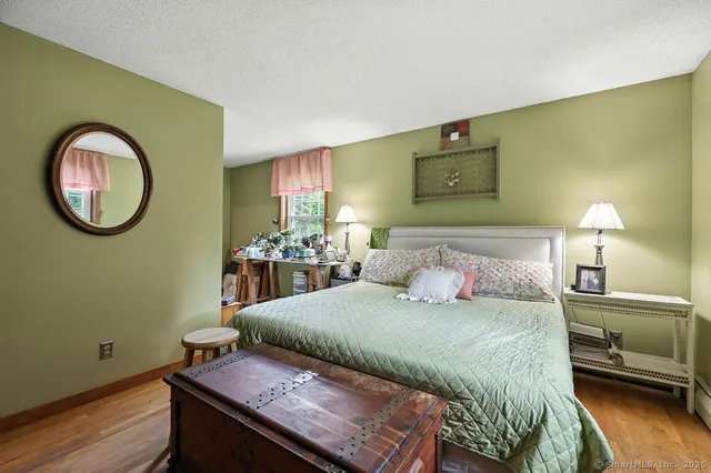 a bedroom with a bed and a lamp on dresser