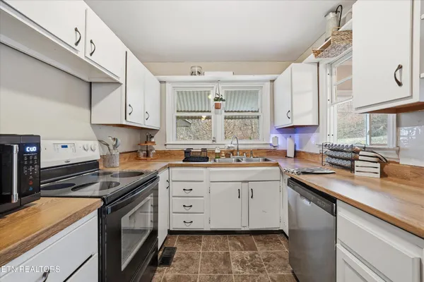 a kitchen with a sink stove top oven and cabinets