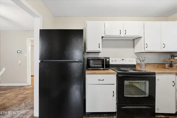 a kitchen with a refrigerator stove and white cabinets