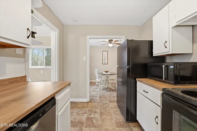 a kitchen with granite countertop a refrigerator stove and sink