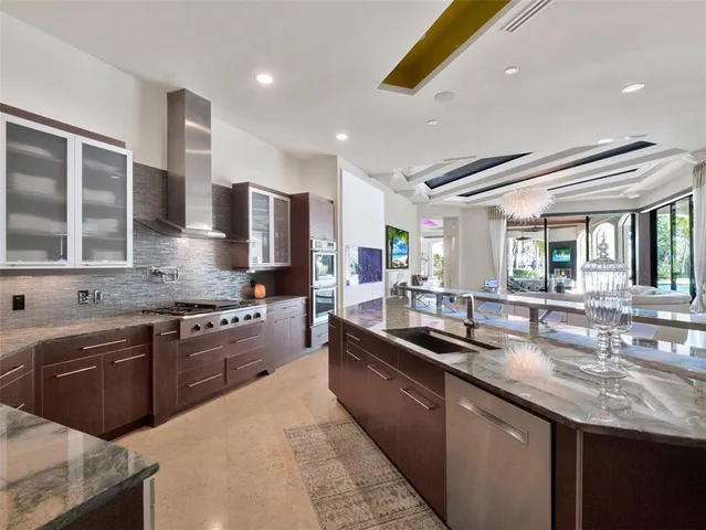 a kitchen with stainless steel appliances granite countertop a sink a stove and a cabinets