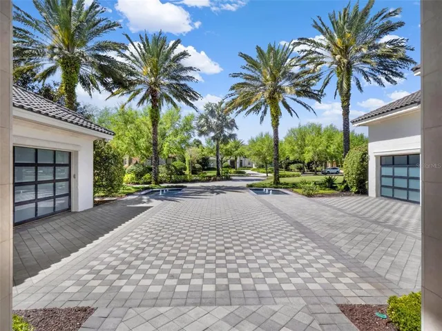 a view of multiple houses with a yard and palm trees