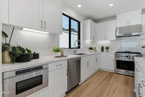a kitchen with a white cabinets and appliances