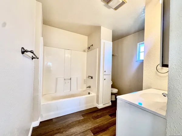 a bathroom with a granite countertop sink a toilet and shower