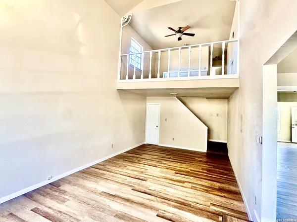 a view of a livingroom with wooden floor and a ceiling fan