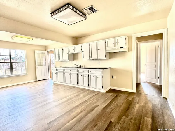 a large kitchen with cabinets and wooden floor