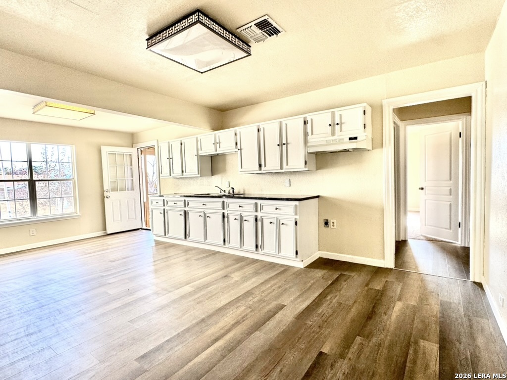 19524 South Benton Street Lytle, TX 78052 - Photo 7 of 22 a large kitchen with cabinets and wooden floor