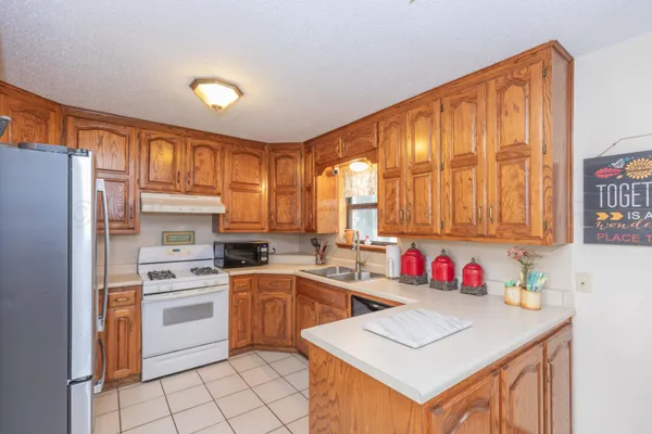 a kitchen with stainless steel appliances granite countertop a stove a sink dishwasher a refrigerator and cabinets with wooden floor