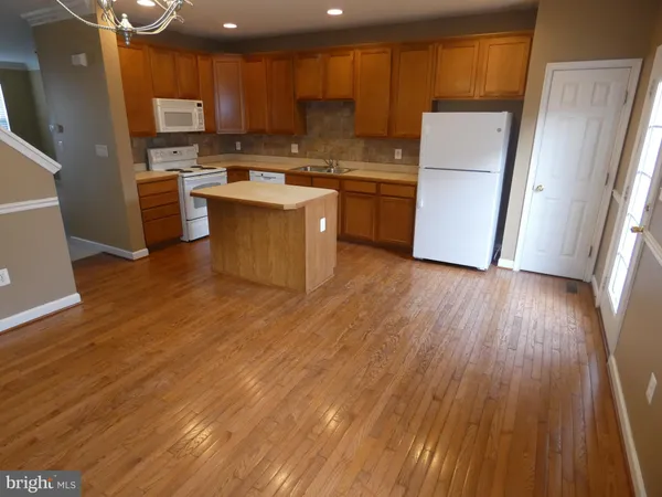 a kitchen with a refrigerator a stove top oven a sink and cabinets