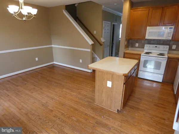 a kitchen with kitchen island a counter top space a stove and wooden floor