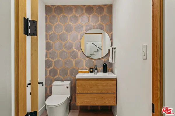 a bathroom with a sink mirror vanity and toilet