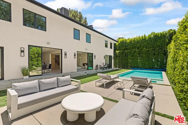 a outdoor space with patio couches coffee table and potted plants with sky view