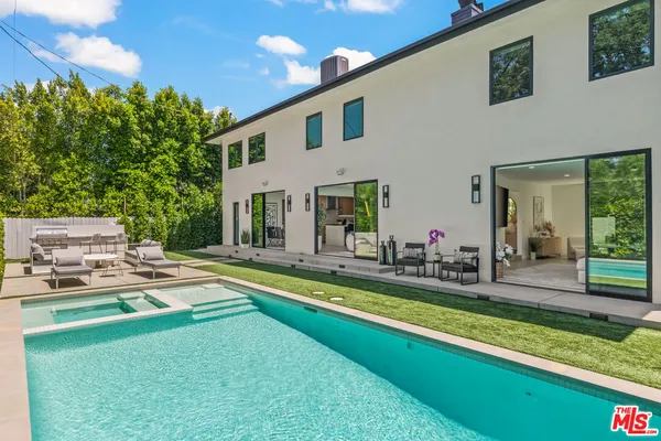 a view of a house with swimming pool and a yard