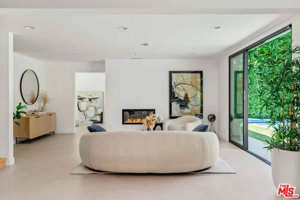 a living room with furniture a large window and a chandelier