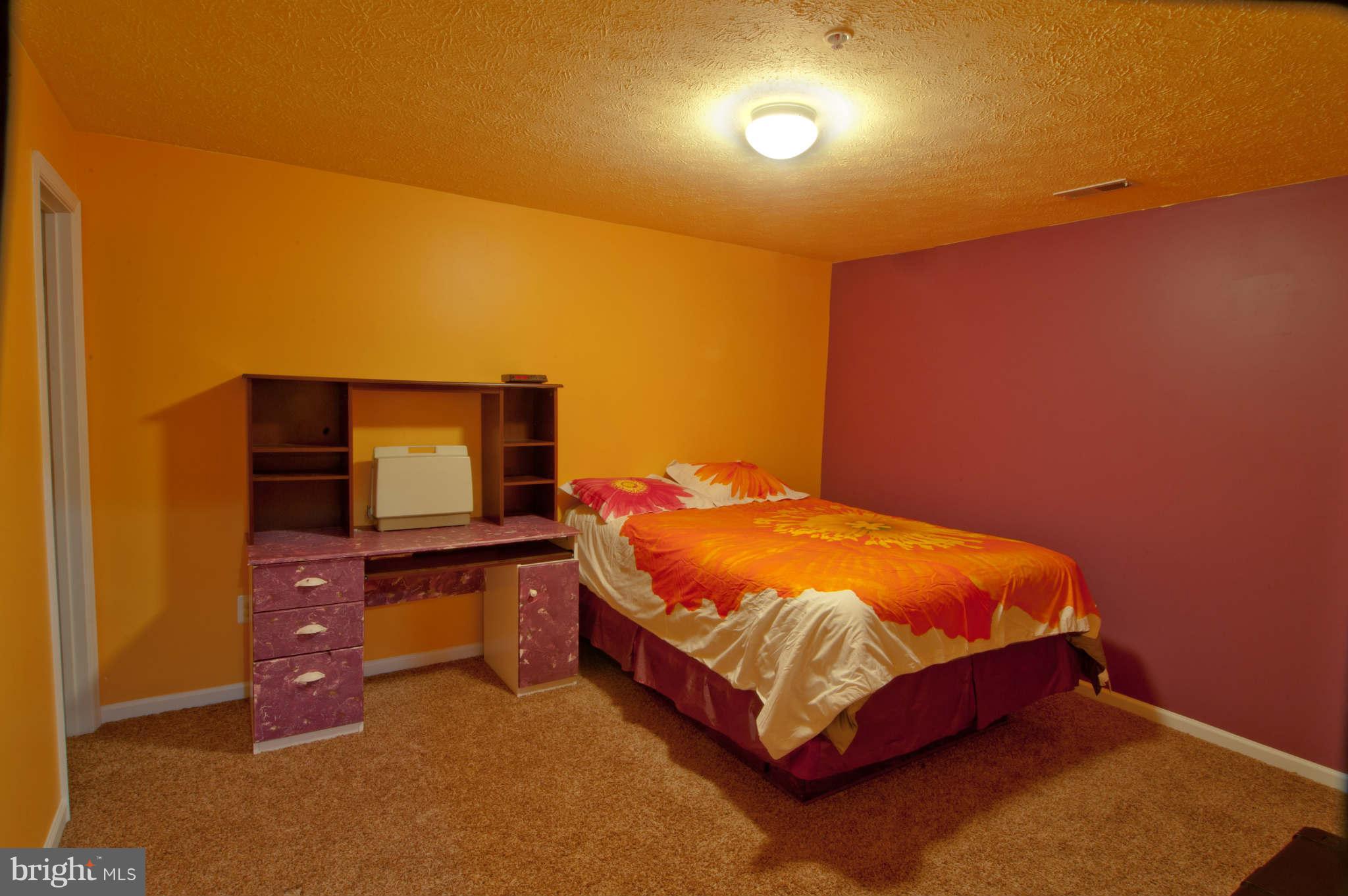 9661 Biggs Road Baltimore, MD 21220 - Photo 20 of 25 a bed sitting in a room next to a lamp