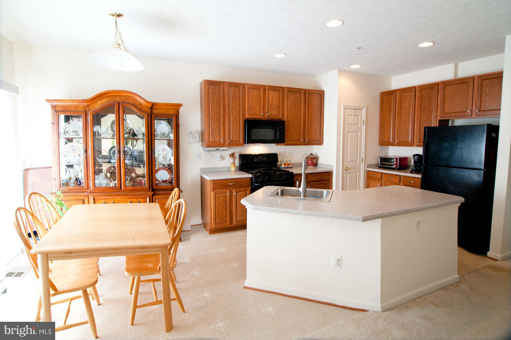 9661 Biggs Road Baltimore, MD 21220 - Photo 10 of 25 a living room with furniture a flat screen tv and a refrigerator