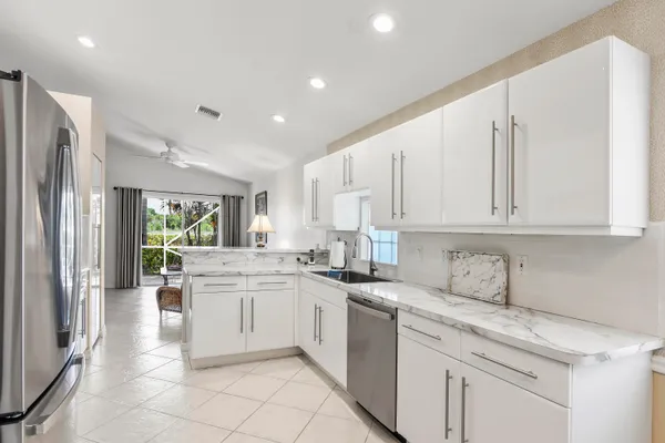 a kitchen with white cabinets and white appliances