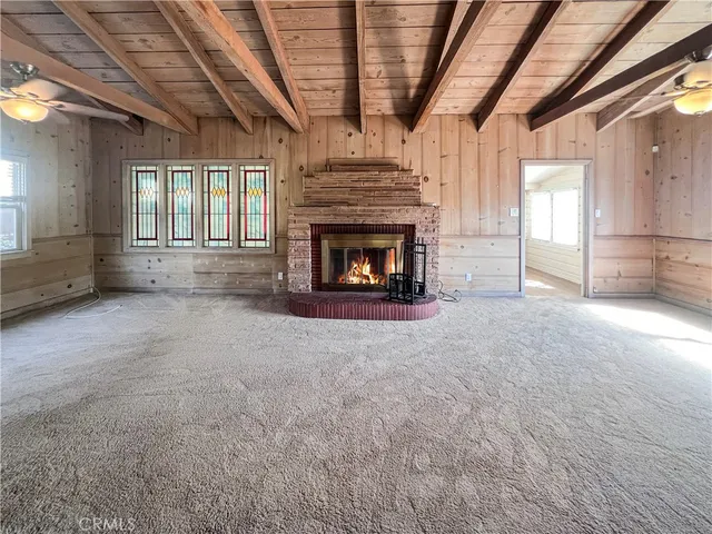 a view of an empty room with a fireplace and a window
