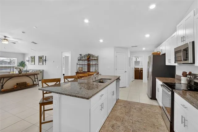 a kitchen with stainless steel appliances granite countertop a sink and a refrigerator