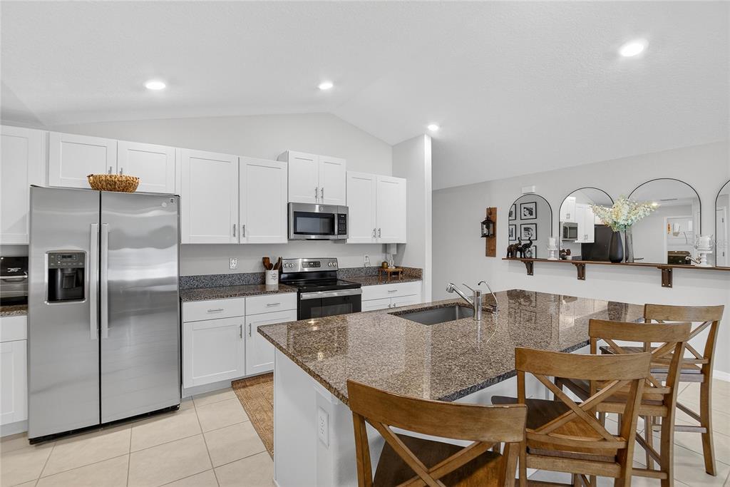 2950 Flying Blackbird Road Bartow, FL 33830 - Photo 14 of 41 a kitchen with stainless steel appliances granite countertop a refrigerator a stove a sink a dining table and chairs