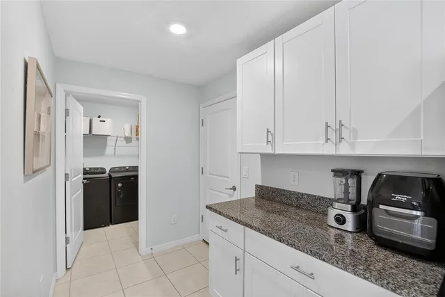 a kitchen with granite countertop white cabinets and stainless steel appliances