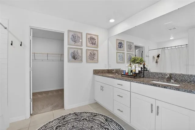 a spacious bathroom with a granite countertop sink and a mirror