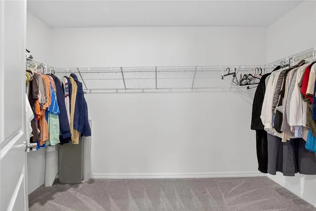 a view of walk in closet with clothes