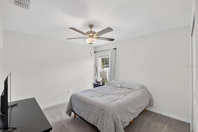 a bedroom with a bed and a ceiling fan