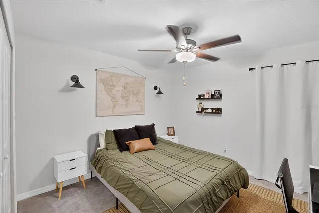 a bedroom with a bed and a ceiling fan