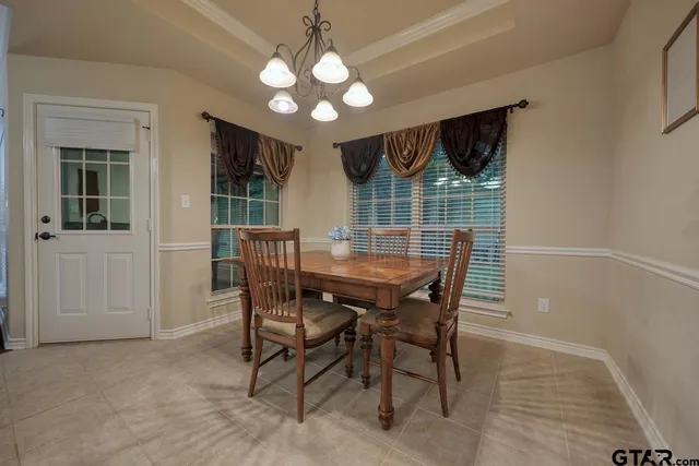 a view of a dining room with furniture and chandelier