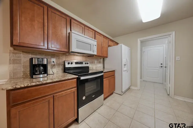 a kitchen with stainless steel appliances granite countertop a refrigerator sink and cabinets