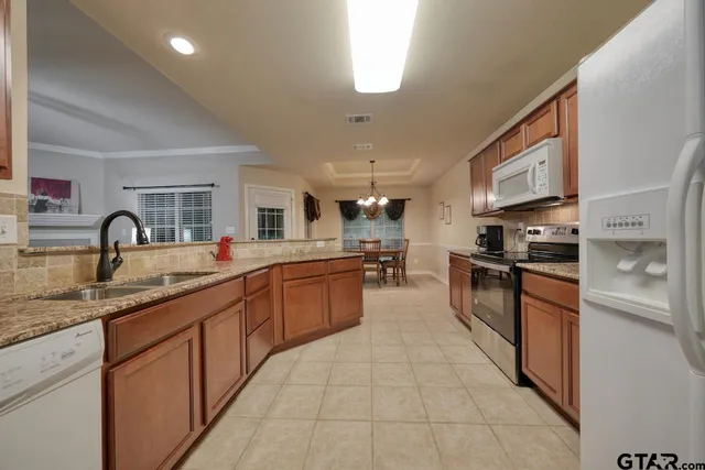 a kitchen with stainless steel appliances granite countertop a sink and cabinets