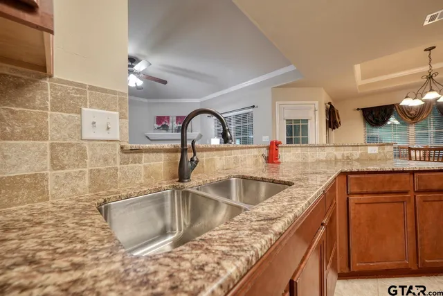 a kitchen with granite countertop a sink and a wooden cabinets
