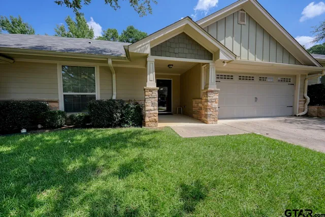 a view of a house with brick walls and a yard with plants