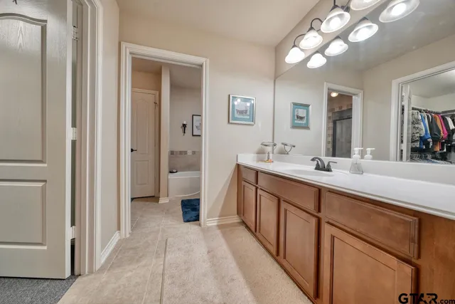 a spacious bathroom with a double vanity sink a mirror and a shower