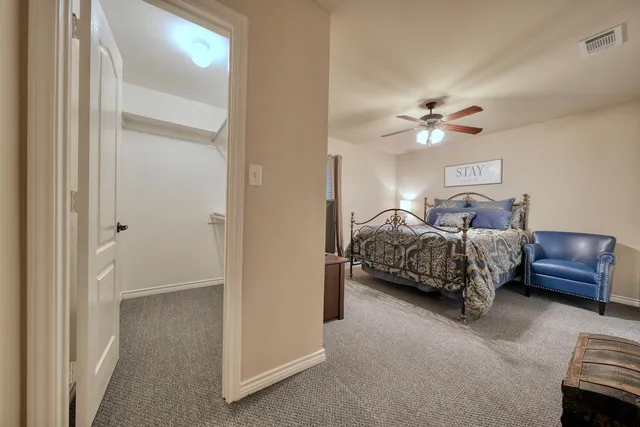 a bedroom with a bed a chandelier and a painting on the wall