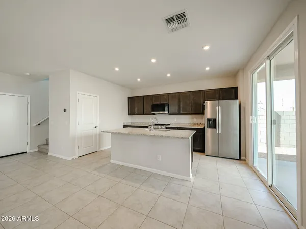 a view of kitchen with stainless steel appliances refrigerator oven and cabinets