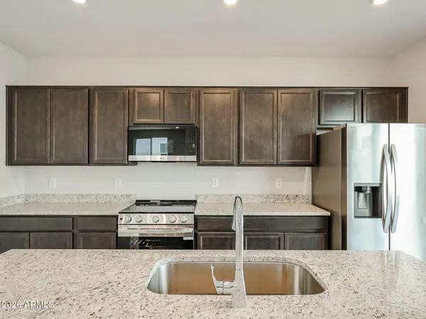 a kitchen with stainless steel appliances wooden cabinets a refrigerator and a sink