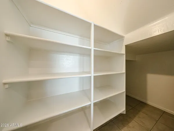 a view of walk in closet with empty racks