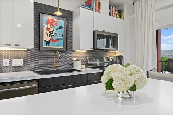 a kitchen with stainless steel appliances granite countertop a stove a sink and a microwave