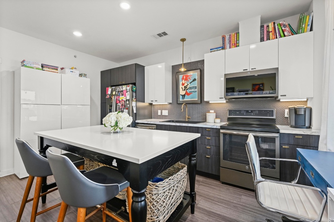 4361 South Congress Avenue, Unit 427 Austin, TX 78745 - Photo 11 of 33 a kitchen with a table chairs a microwave and cabinets