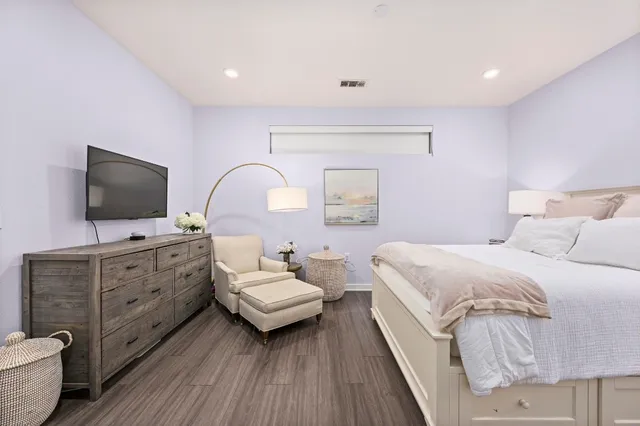 a spacious bedroom with a bed and a flat screen tv