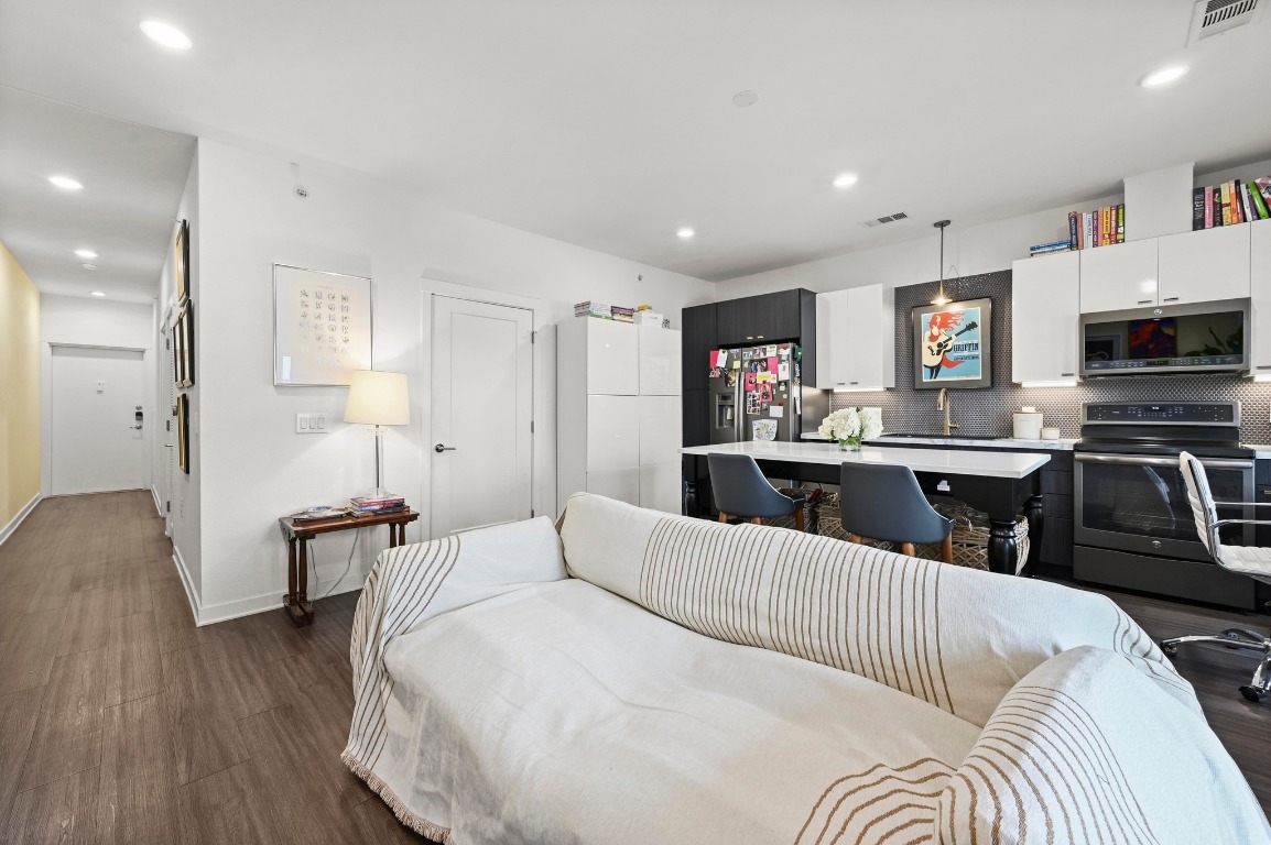 4361 South Congress Avenue, Unit 427 Austin, TX 78745 - Photo 8 of 33 a kitchen with stainless steel appliances kitchen island granite countertop a sink and cabinets
