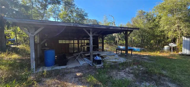a view of a patio with table and chairs under an umbrella with a small yard