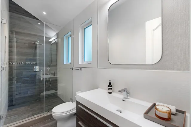 a bathroom with a sink a toilet and shower