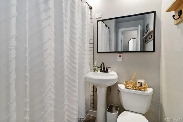 a bathroom with a toilet sink and mirror